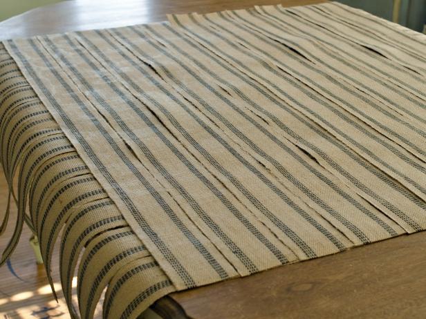 Line up all lengths of upholstery webbing for making the table runner. Run another piece of webbing across length and cut to size with sharp scissors — no excess overhang is necessary. Repeat this process until entire width of runner is covered