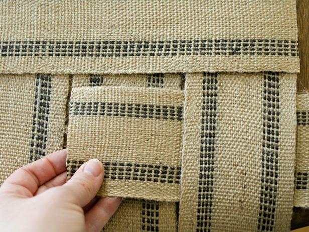 Weave first length of upholstery webbing in an over-under pattern through widths of webbing for the table runner. Do this only with the first row in this step.