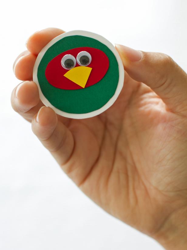 After attaching the circles to form the pheasant head for your Thanksgiving place cards, give your decoration a little personality. Add googly eyes and a small yellow construction paper beak to finish the pheasant face.