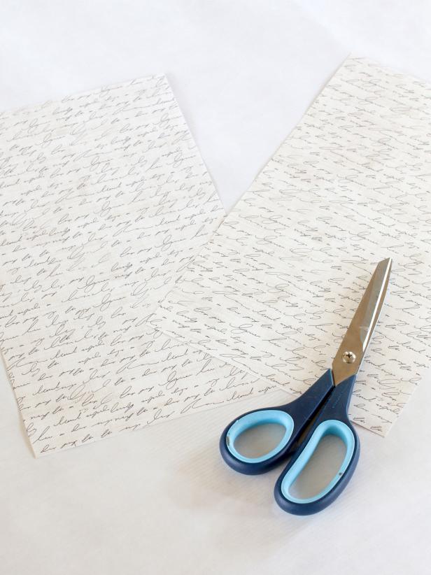 To create the paper sails for your ship centerpiece, first use scissors to cut two rectangles out of light-colored patterned paper.