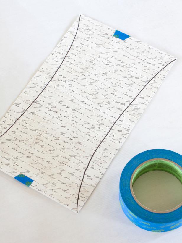 When creating the sails for the ship centerpiece, align the two pieces of paper (both patterned sides facing out) and use painter's tape to secure the papers' tops and bottoms.