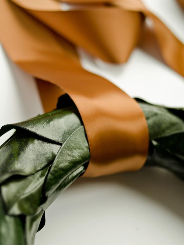 After attaching Magnolia leaves together to form the wreath, loop a wide, double-sided satin ribbon around completed wreath to hang it.