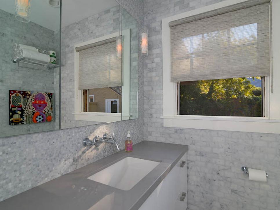 White and Gray Marble Bathroom With Window and Colorful Art
