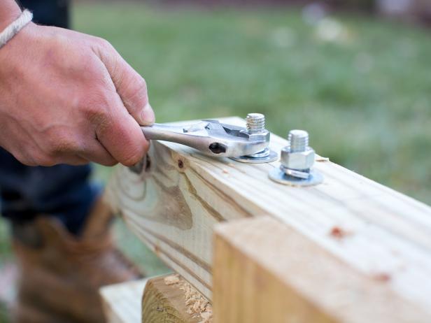 Use adjustable wrench to tightly fasten lag bolts and fender washers through 6x4s and 4x4s.