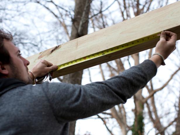Standing on ladder, use measuring tape to determine exact width of crossbeam starting from the inside edge of each of the support beam.