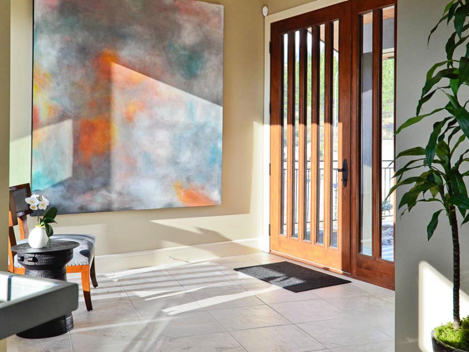 Transitional Entryway With Colorful Artwork and Detailed Wooden Door 