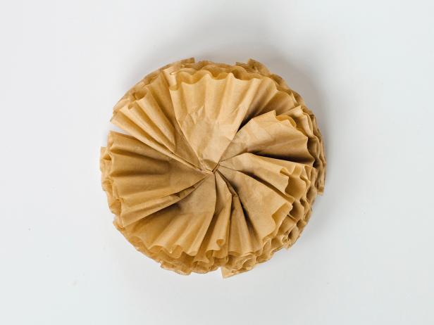 Attach folded coffee filters to a 2-inch card-stock circle using hot glue, overlapping them as you go until the circle is full