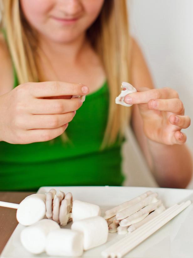 Break the top off two pretzel knots to become the skeleton's arms.