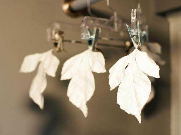 Gently shake off excess and clip the leaves onto a hanger with the points facing down. Repeat for all leaves.