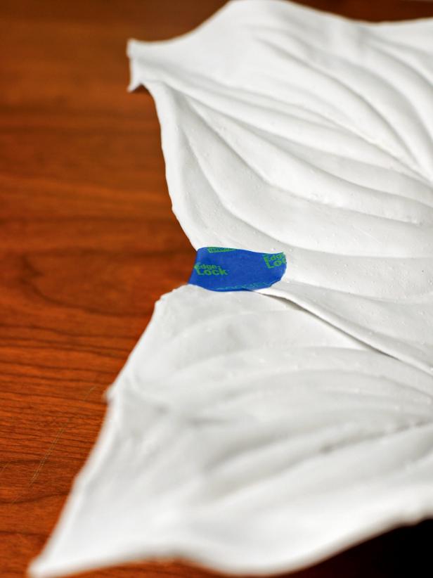 Arrange the dried leaves to form a tray by overlapping the sides. Hold them together temporarily with painter's tape.
