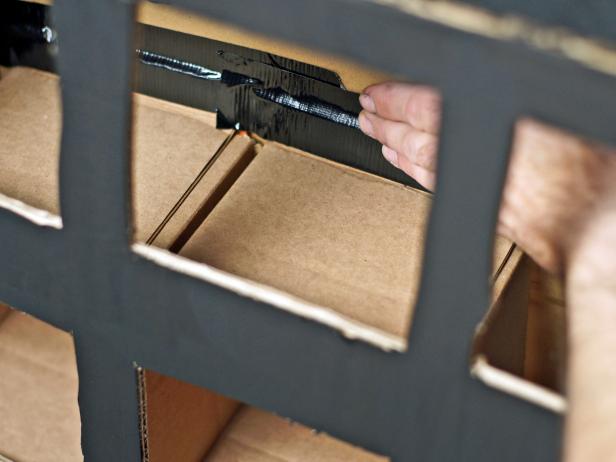 Insert small shipping boxes inside the TV box, positioned carefully between the front and back holes with the felt pumpkin flaps facing out. Use black duct tape to secure flaps to the inside of the TV box; this will keep each box properly lined up with each opening