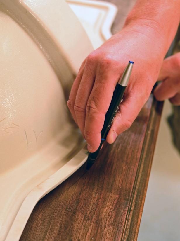 The area where a sink will be installed is marked on a vintage dresser.