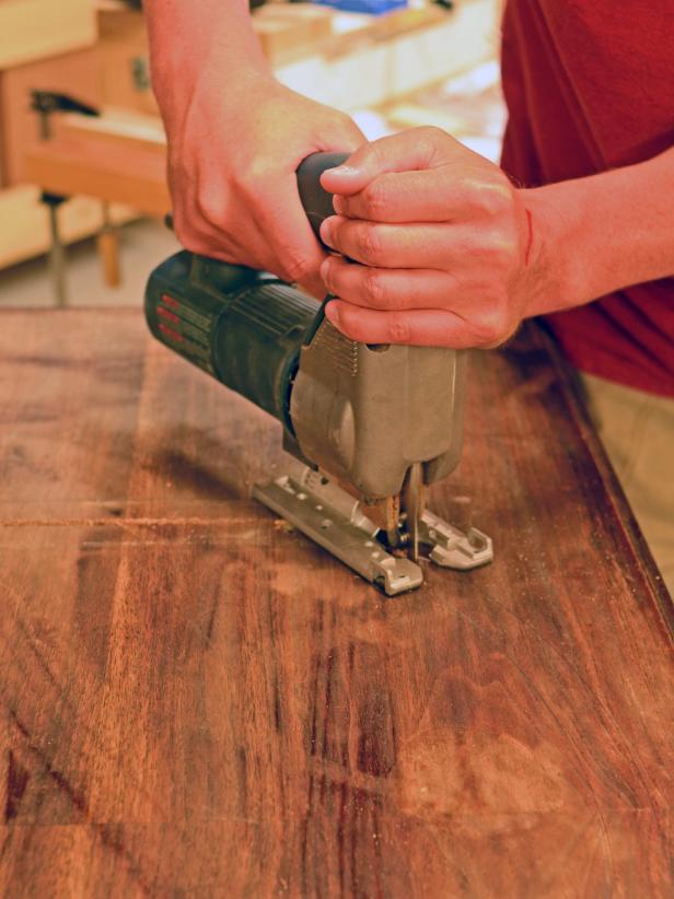 A hole is cut in a vintage dresser ahead of a sink installation.