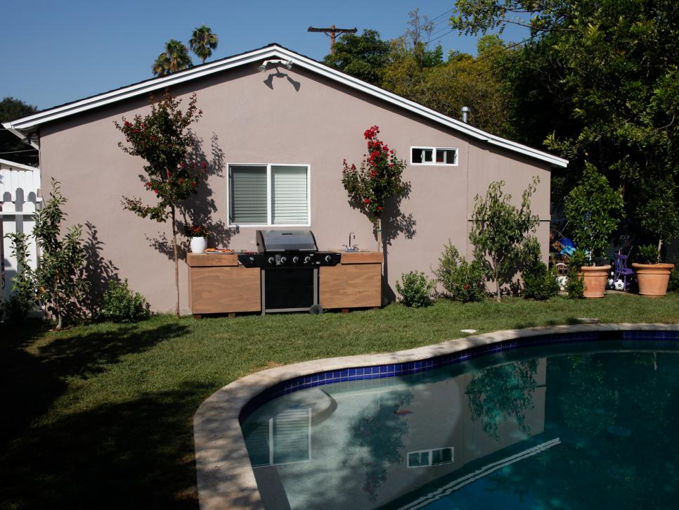 Side view of yard with swimming pool and barbecue grill.
