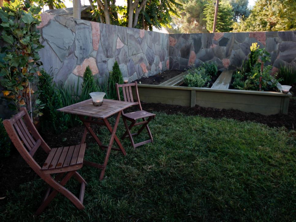Raised Garden Inside Stone Wall With Bistro Table and Chairs