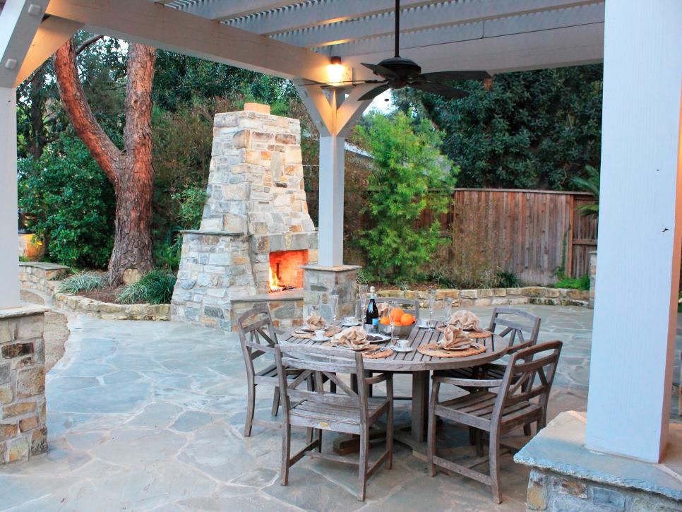 Outdoor Dining Area With Wood Dining Table, Wood Pergola & Fireplace