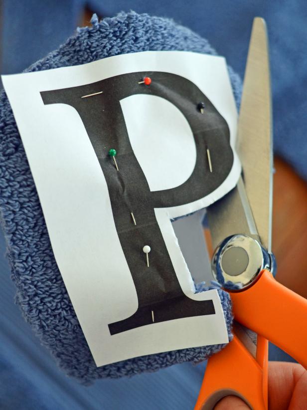 Use sharp scissors to cut around letter, leaving about 1/4-inch border. Remove pins and paper from letter. Trim and clean edges with scissors, if necessary. Tip: Select a block letter style. A font with lots of curves, details and skinny lines will be hard to cut and sew.