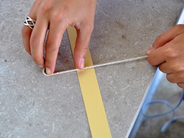 The next step is to press twine along line of hot glue that you applied to the card stock strip.