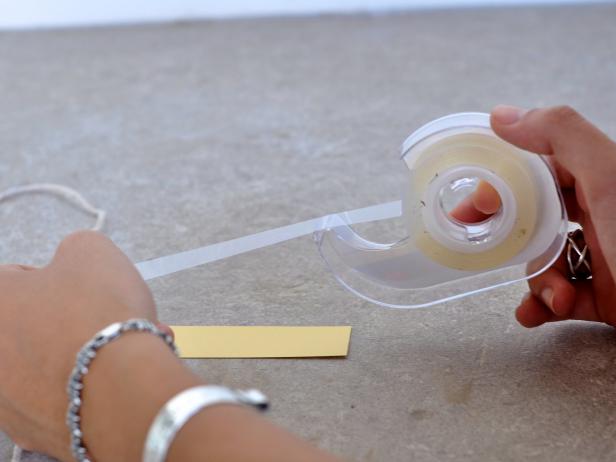 Add a small piece of double-sided tape to one end of strip.