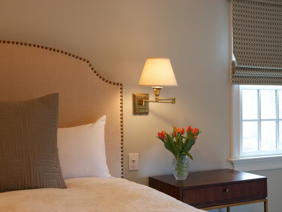 Nailhead Upholstered Headboard & Wall-Mounted Lamp in Neutral Bedroom