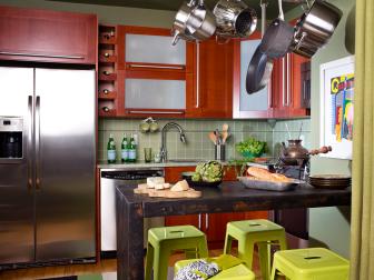 Sage Eat-In Kitchen With Distressed Black Table and Wood Cabinetry