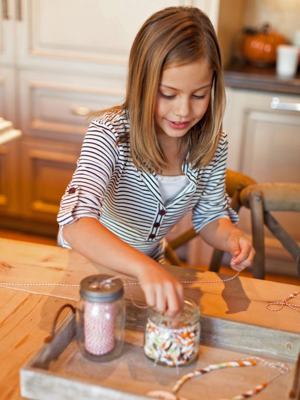 Use scissors to cut a piece of twine the desired length for the necklace. String straws in a pattern or at random to the half way point of the necklace.