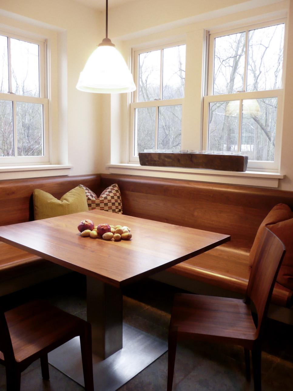 White Dining Nook With Windows Above Wood Banquette and Table