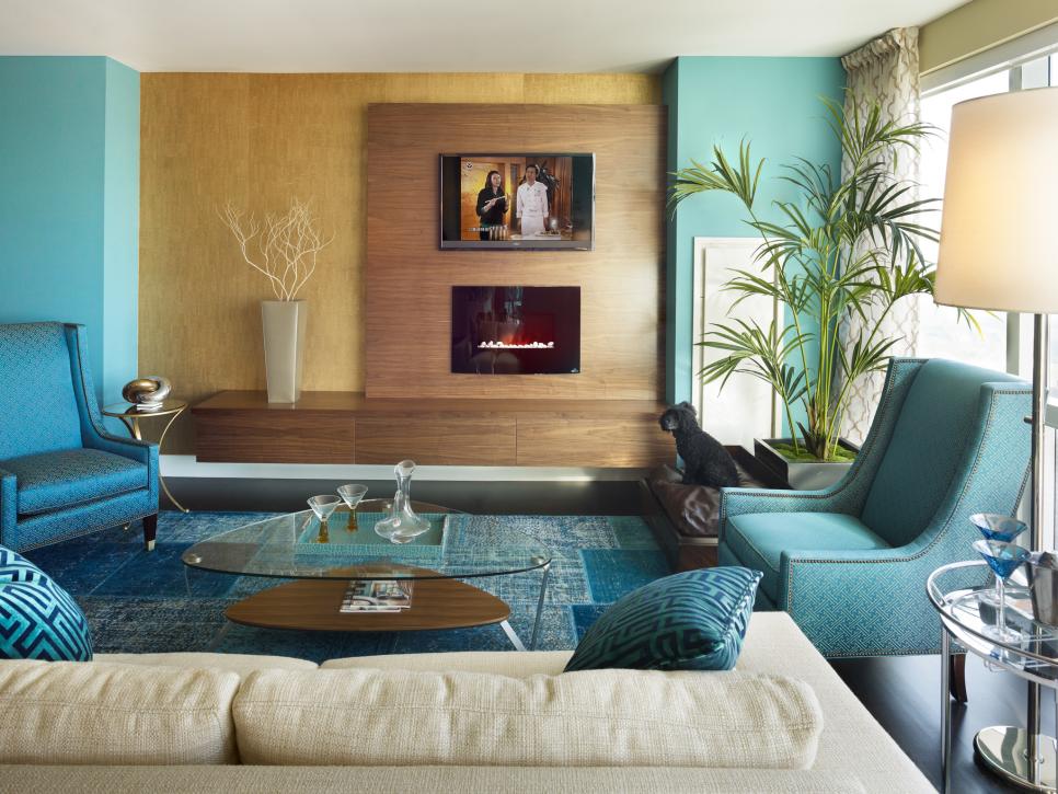 Turquoise Living Area With Wood Hearth, Blue Chairs and Glass Table