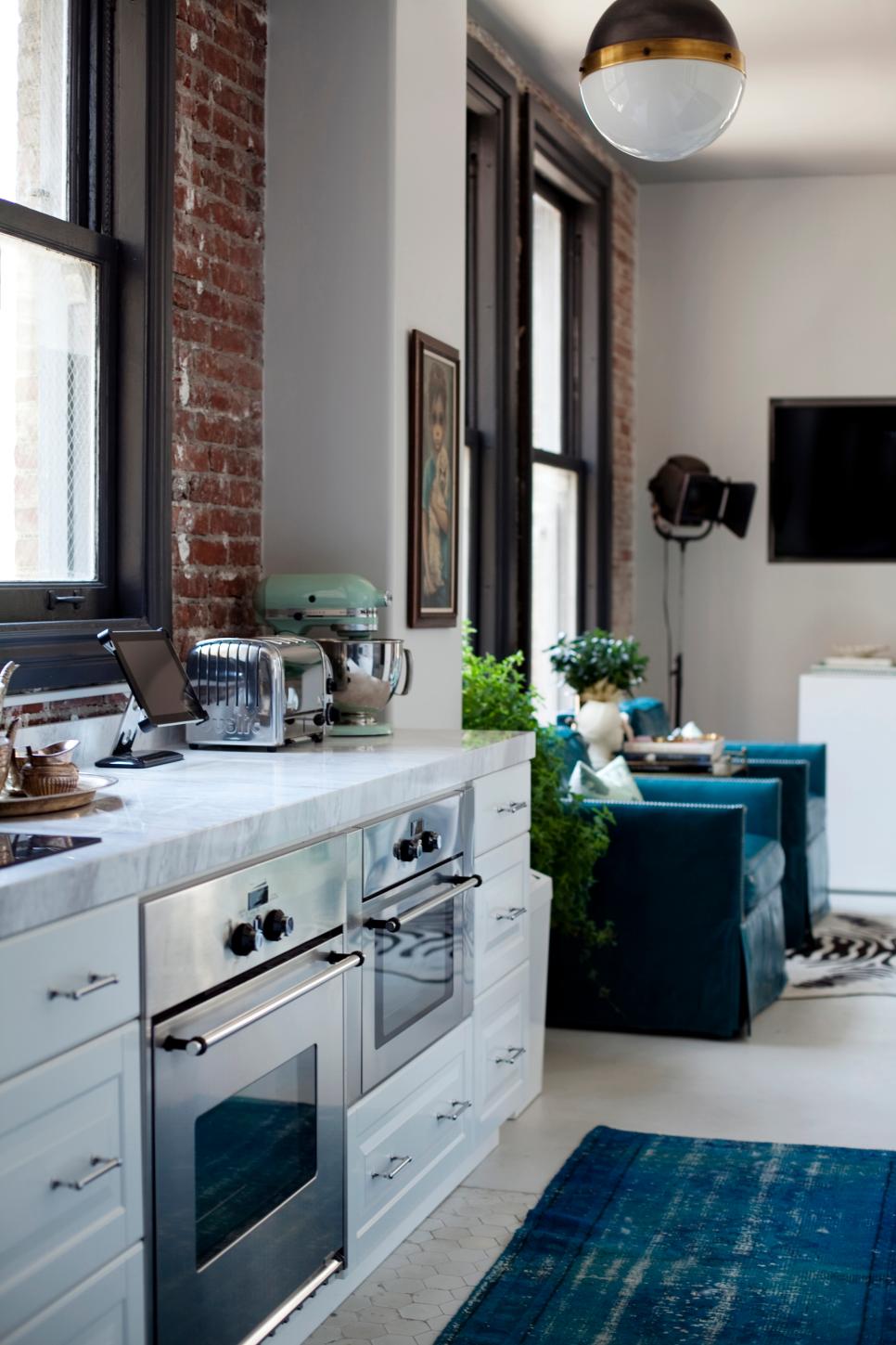 Sophisticated Contemporary Kitchen With White Cabinetry and Marble Counters Small White Loft Kitchen With Stainless Steel Appliances