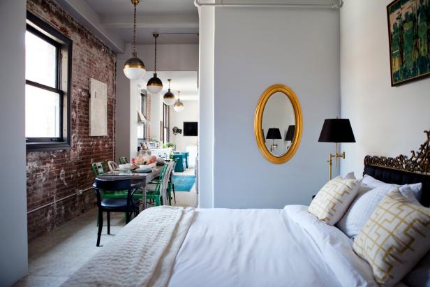Small White Bedroom Features Gold Mirror, Ornate Headboard Gold Mirror Beside Bed in Tiny, Open Bedroom