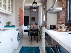 Galley Kitchen With Pendant Lights and Exposed Brick 