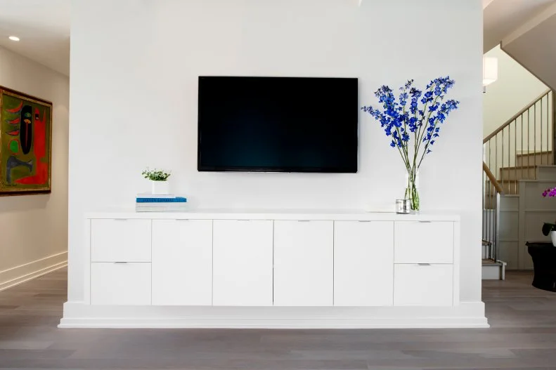 White Modern Entertainment Center With Vase of Blue Flowers