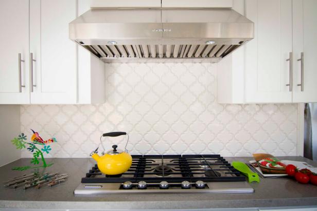 White Tile Backsplash Behind Gas Range With Yellow Kettle