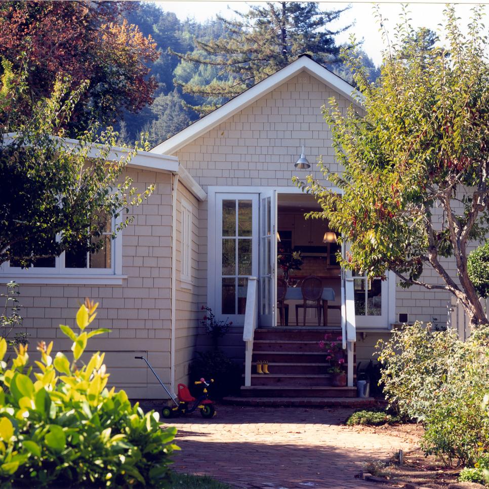 Beige Cottage Exterior With Porch Stairs and White French Doors
