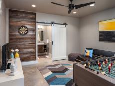 Neutral Transitional Game Room With Ceiling Fan, Barn Door & Wood Wall