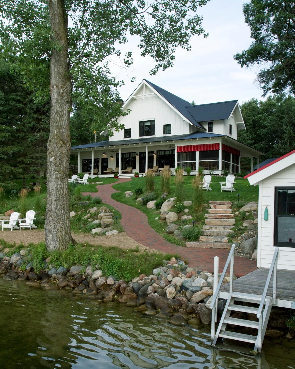 Farmhouse With Lake Views White Farmhouse Exterior With Landscaped Yard & Adirondack Chairs
