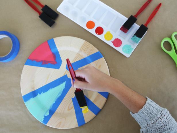Take wood chargers from basic to to bright by using painter's tape and bold paint hues.