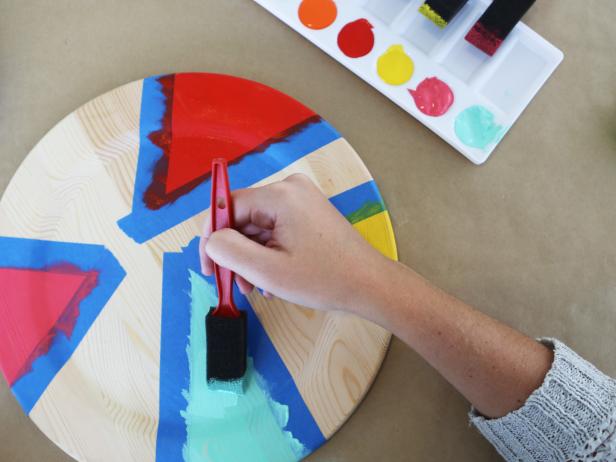 Take wood chargers from basic to to bright by using painter's tape and bold paint hues.
