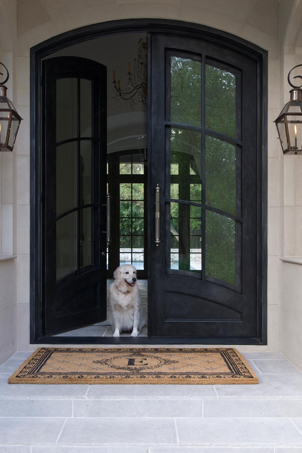 Elegant Entry With Arched Double Doors Entry With Black Double Doors, Monogrammed Doormat and Dog