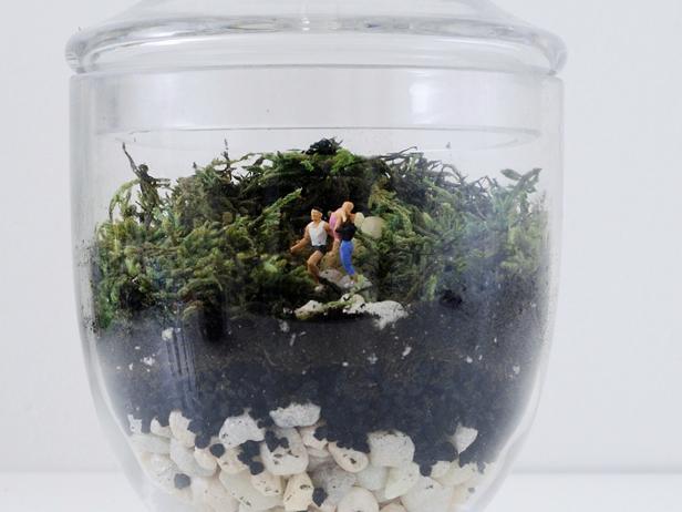 Terrariums are one of the easiest ways to keep plants alive in your home. Make one with a tiny family inside using miniature train display figures.