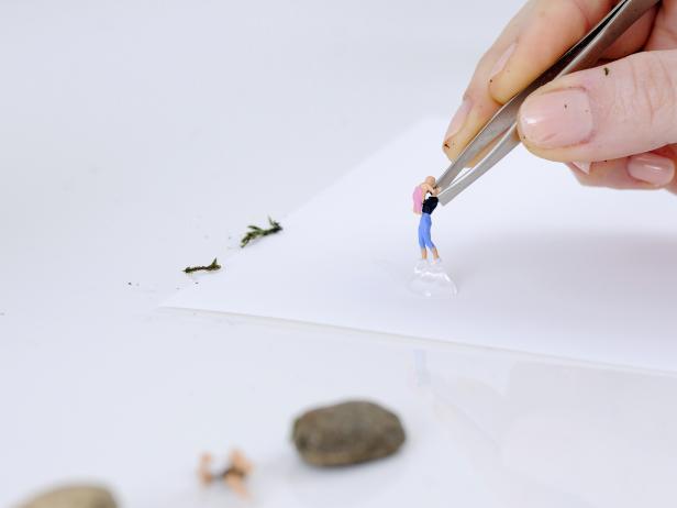 Dip the feet of your first terrarium figure in waterproof glue.
