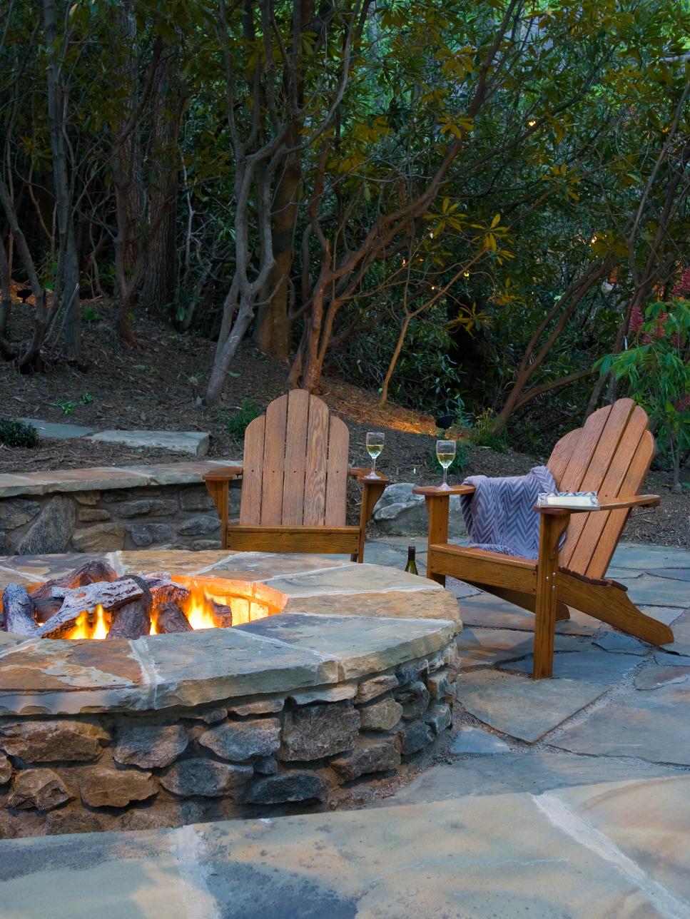 Backyard Stone Fire Pit With Wood Adirondack Chairs