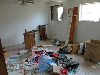 Messy garage with tile floor before renovation.