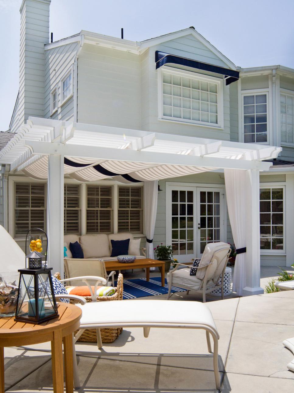 Hamptons-Inspired Outdoor Living Space With Poolside Seating and Shaded Area