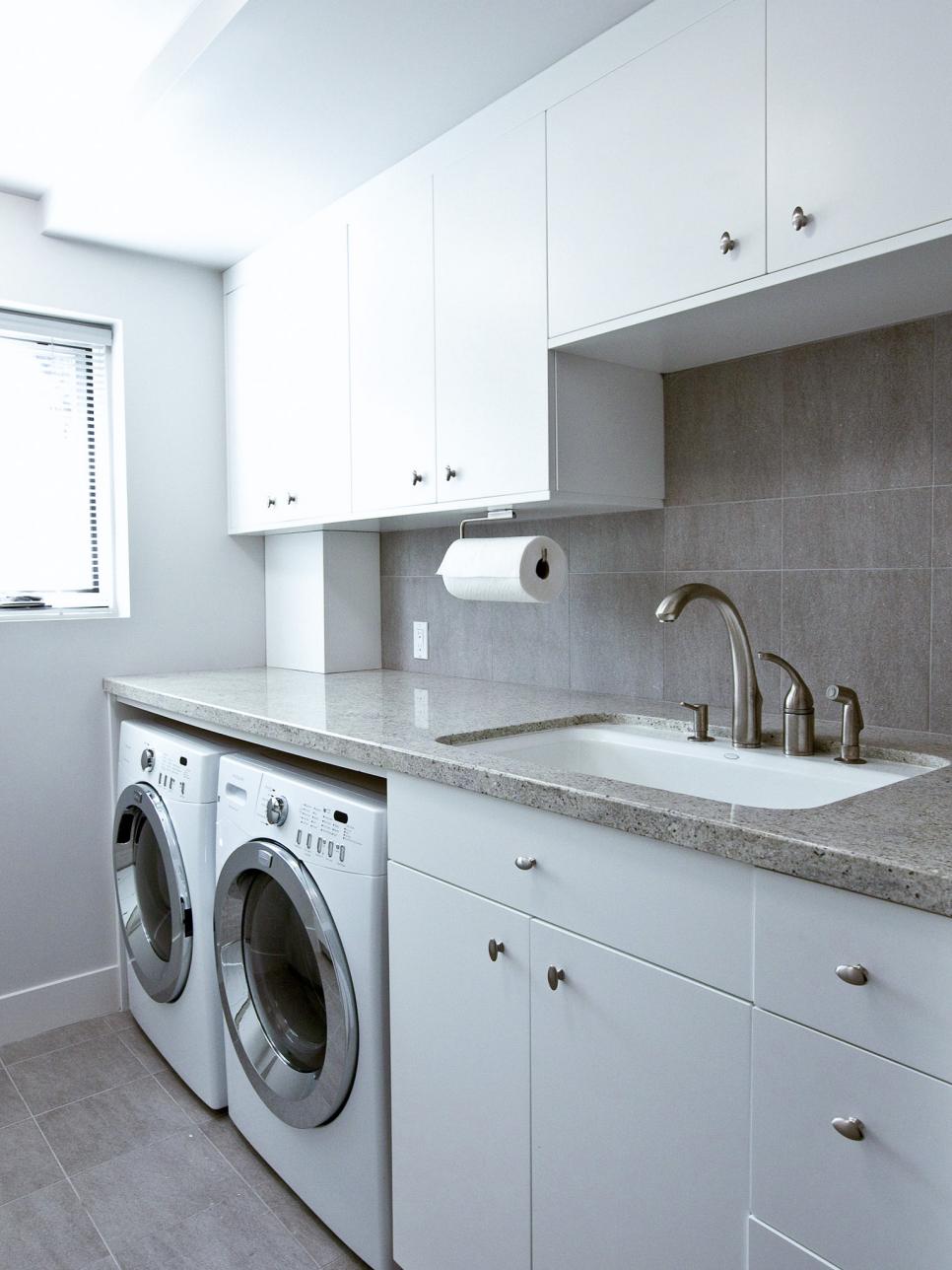 White Laundry Room with Washer, Dryer, Sink, and Cabinet Storage