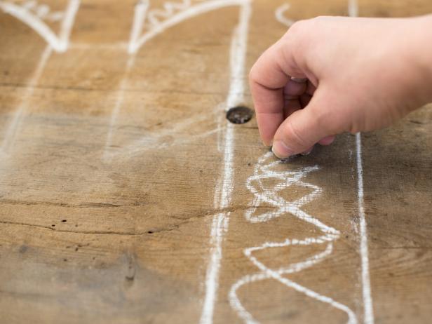 Since old bread boards have a primitive shape, draw designs freehand without worrying too much about perfect symmetry. Scribble out areas that will be scraps to make sketches clear when cutting.