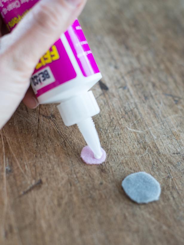 Apply a small amount of fabric glue to one side of a pink circle.