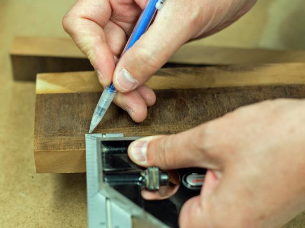 Determine center point of width of cookbook stand's back board with combo square and transfer that measurement to bottom piece. Mark with pencil.