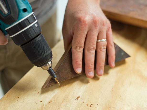 Fit drill with countersink bit. Hold bit up to edges of cookbook stand support to determine proper placement of screws to attach supports to back of stand.