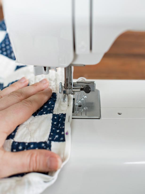 Cover the entire perimeter of quilt, slit and tree trunk hole with quilt binding. Sew along the binding edge and remove the pins.